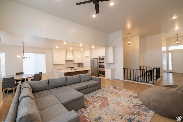 293 N Pheasant Dr, Mapleton, UT 84664 - living room with light wood-style flooring, ceiling fan with notable chandelier, and recessed lighting