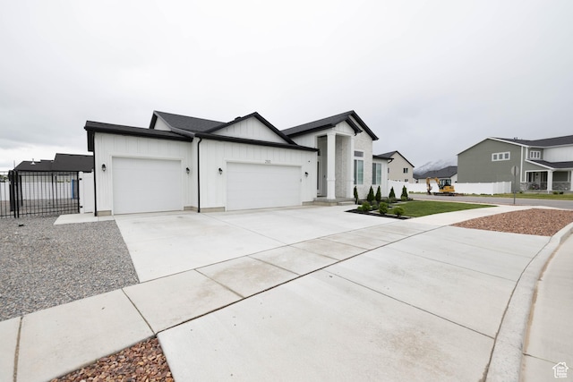 293 N Pheasant Dr, Mapleton, UT 84664 - view of front facade featuring a garage, board and batten siding, fence, concrete driveway, and a residential view