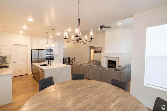 293 N Pheasant Dr, Mapleton, UT 84664 - dining space featuring recessed lighting, light wood finished floors, a chandelier, and a glass covered fireplace