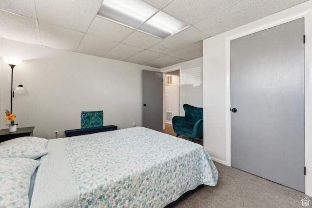 bedroom featuring a drop ceiling, visible vents, and carpet floors