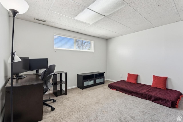 office area featuring carpet, visible vents, a drop ceiling, and baseboards