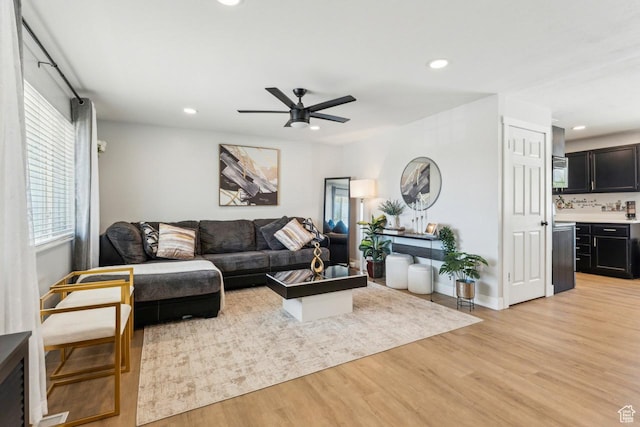 living area with light wood-style floors, baseboards, a ceiling fan, and recessed lighting