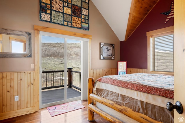 679 N Cambry Dr, Garden City, UT 84028 - bedroom with a wainscoted wall, hardwood / wood-style floors, wooden walls, access to outside, and vaulted ceiling