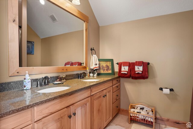 679 N Cambry Dr, Garden City, UT 84028 - bathroom featuring lofted ceiling, double vanity, tile patterned floors, and baseboards