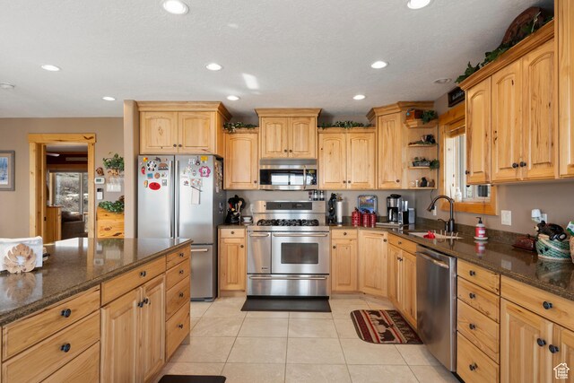 679 N Cambry Dr, Garden City, UT 84028 - kitchen featuring stainless steel appliances, a sink, dark stone countertops, recessed lighting, and light tile patterned floors