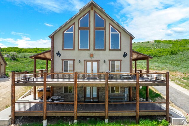 679 N Cambry Dr, Garden City, UT 84028 - rear view of house featuring french doors, a wooden deck, stucco siding, and stone siding