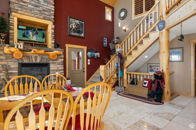 679 N Cambry Dr, Garden City, UT 84028 - dining area with high vaulted ceiling, stairway, a fireplace, and baseboards