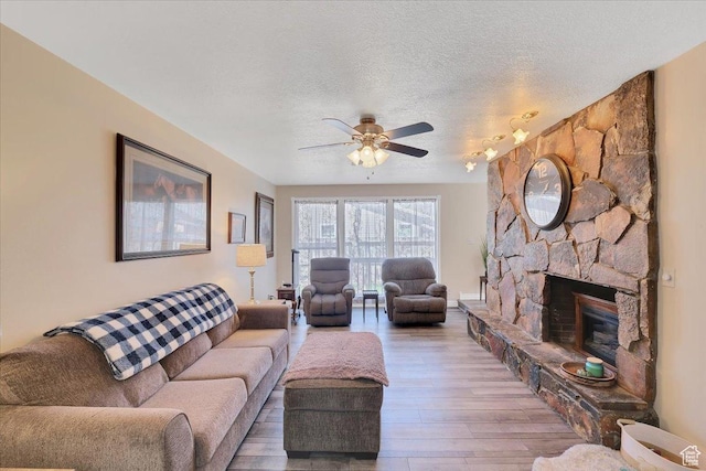 1480 N 1525 E, Logan, UT 84341 - living room featuring a textured ceiling, wood finished floors, ceiling fan, and a fireplace