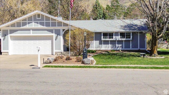 view of front of property with a garage, driveway, and a front lawn