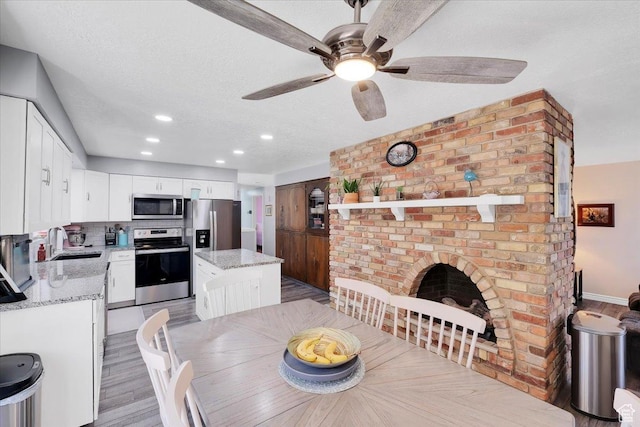 1480 N 1525 E, Logan, UT 84341 - dining area featuring a fireplace, recessed lighting, light wood-style flooring, a textured ceiling, and a ceiling fan