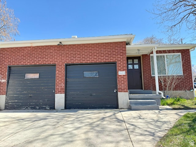 view of front of house with a garage, brick siding, and concrete driveway