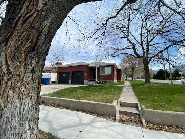 view of front of house with concrete driveway, a front lawn, brick siding, and a garage