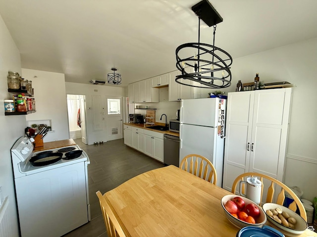 kitchen with white cabinets, white appliances, a sink, and dark wood-style floors