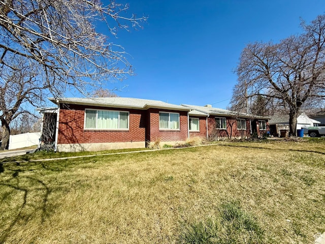 ranch-style house with a front lawn and brick siding