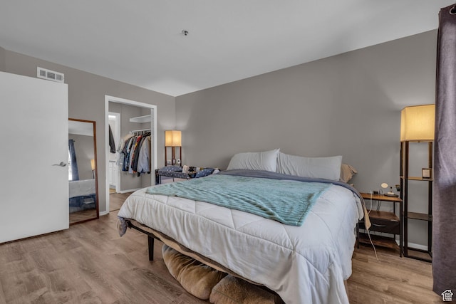 6821 N 2200 W Unit 11K, Park City, UT 84098 - bedroom featuring a walk in closet, visible vents, light wood-type flooring, and a closet