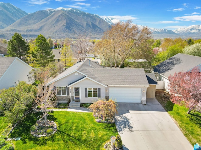 view of front of property with a mountain view, a garage, a front yard, and concrete driveway