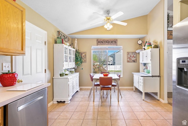 kitchen with vaulted ceiling, light countertops, light tile patterned flooring, ceiling fan, and dishwasher