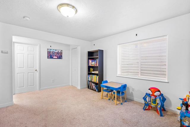 game room featuring carpet flooring, baseboards, and a textured ceiling