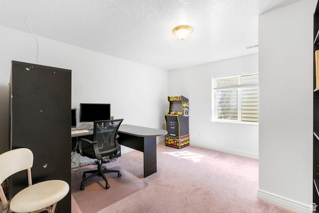 carpeted home office with a textured ceiling, baseboards, and visible vents