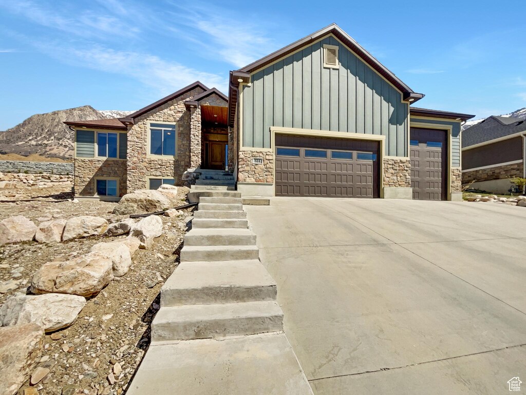 614 E 3800 N, North Ogden, UT 84414 - view of front of home with board and batten siding, an attached garage, stone siding, and driveway