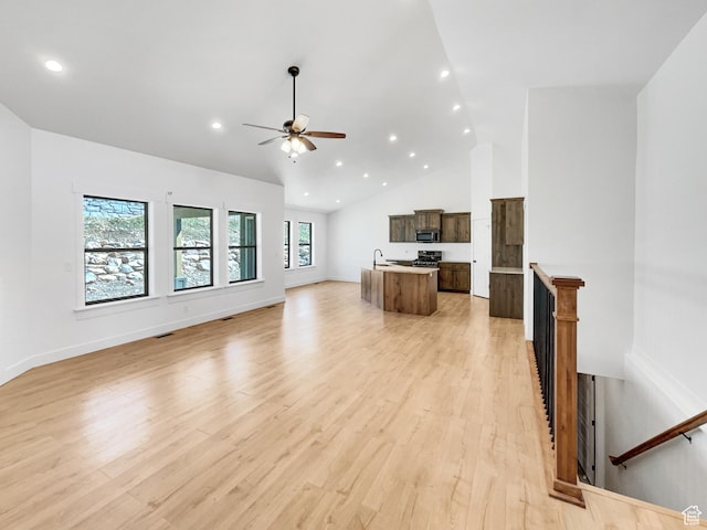 unfurnished living room featuring a sink, a ceiling fan, light wood-style floors, recessed lighting, and high vaulted ceiling