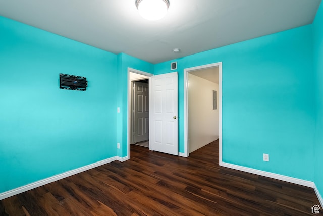 unfurnished bedroom with visible vents, baseboards, and dark wood-style floors