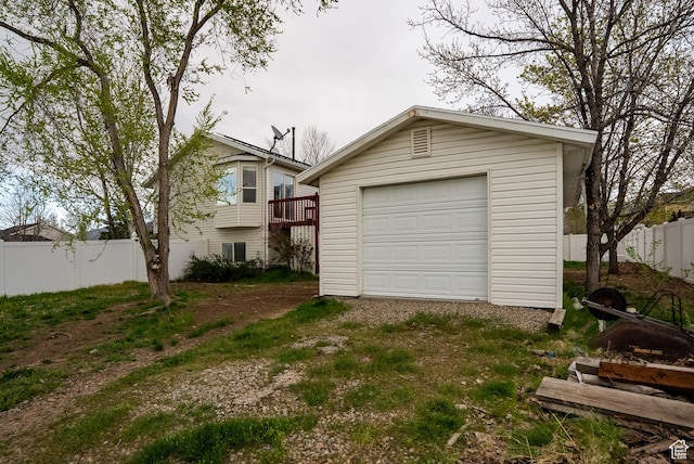 detached garage featuring fence