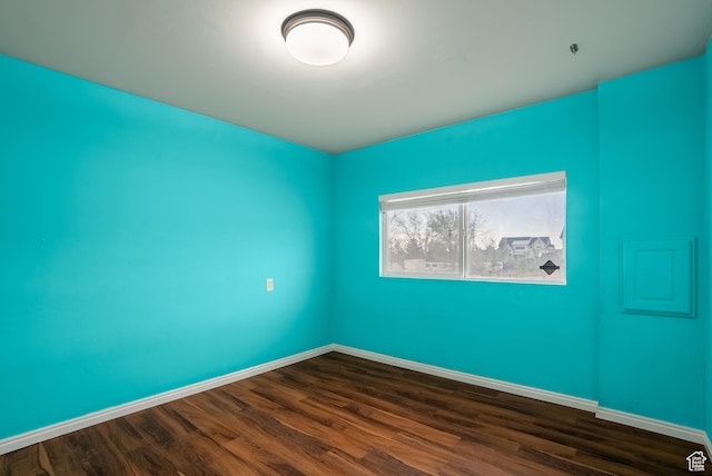 empty room with baseboards and dark wood-style floors