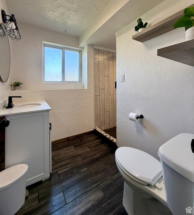130 S 500 W, Roosevelt, UT 84066 - bathroom with toilet, vanity, a textured ceiling, a textured wall, and wood finished floors