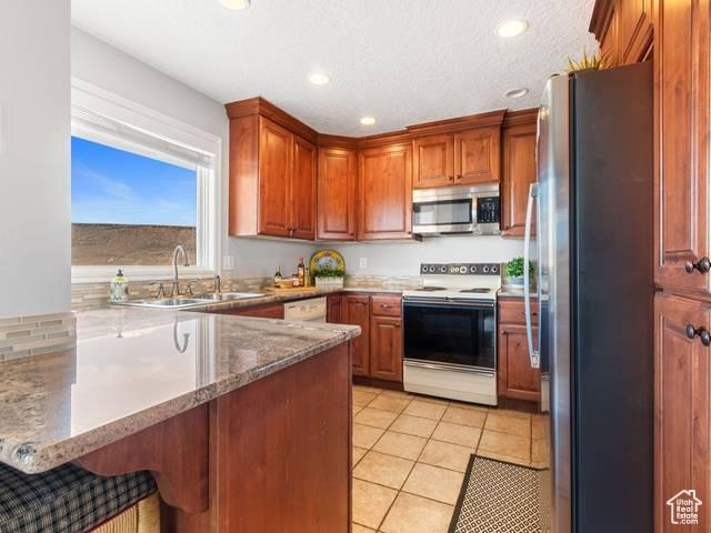 kitchen with recessed lighting, a peninsula, a sink, and appliances with stainless steel finishes