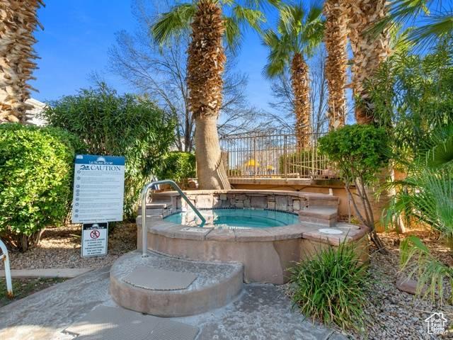 view of pool featuring fence and a community hot tub