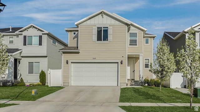 traditional-style house featuring driveway, board and batten siding, a front yard, a garage, and fence