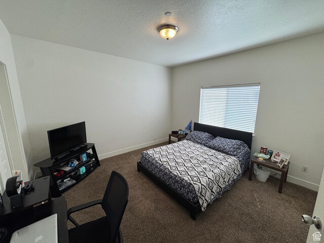 bedroom with a textured ceiling, baseboards, and carpet