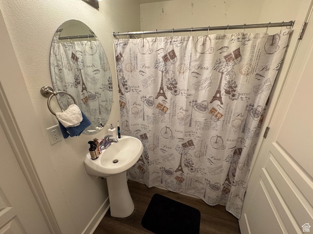 full bathroom featuring wood finished floors and a shower with shower curtain
