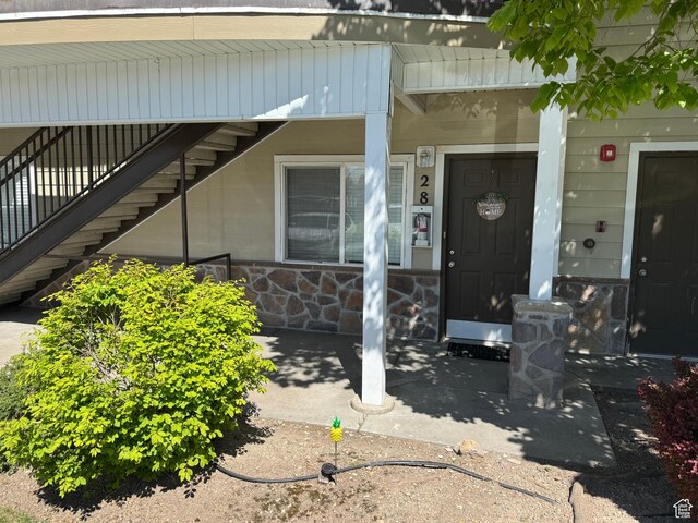 entrance to property featuring a porch and stone siding