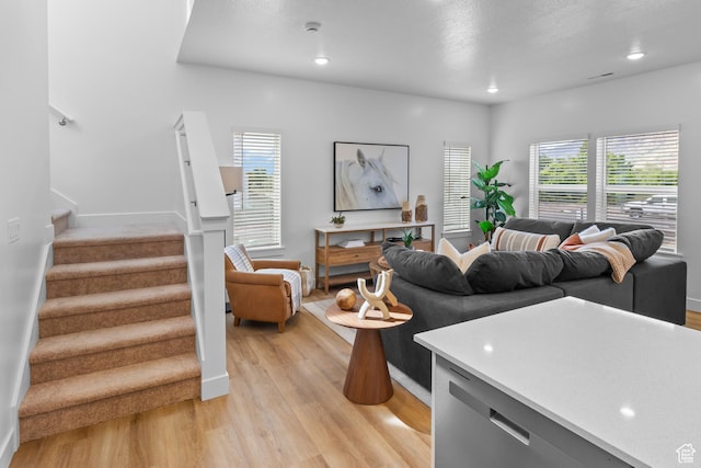 living area featuring baseboards, recessed lighting, light wood-style floors, and stairs