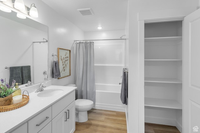 full bathroom with visible vents, shower / bath combination with curtain, toilet, vanity, and wood finished floors