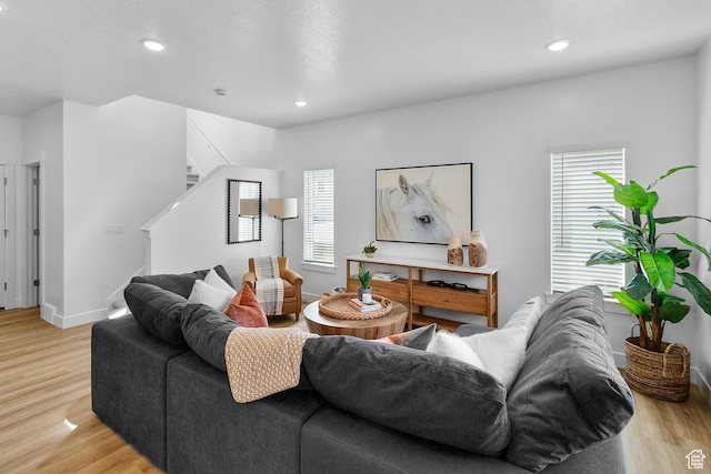 living area featuring light wood-style flooring, recessed lighting, and stairs