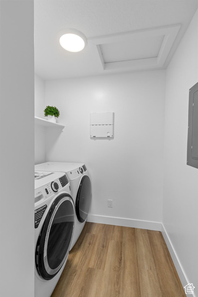 washroom with light wood-type flooring, electric panel, attic access, independent washer and dryer, and laundry area