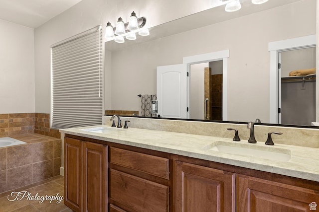 bathroom with a bath, double vanity, a sink, and tile patterned flooring