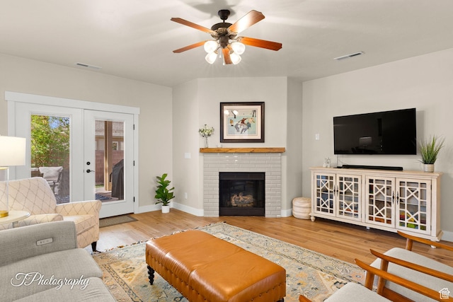 living area featuring french doors, visible vents, baseboards, and wood finished floors