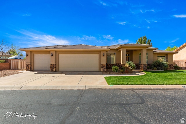view of front of house with an attached garage, stone siding, fence, stucco siding, and driveway