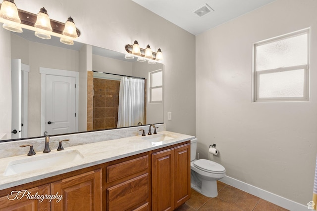bathroom featuring a sink, visible vents, toilet, and tile patterned flooring