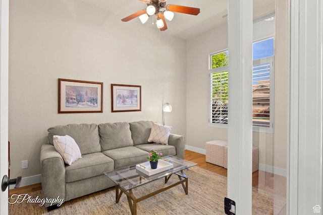 living room with baseboards, ceiling fan, and wood finished floors