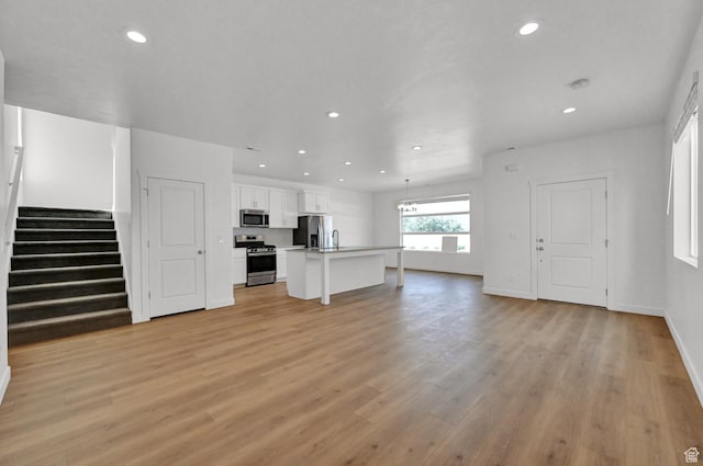 578 S 1080 W, American Fork, UT 84003 - unfurnished living room with light wood-style floors, recessed lighting, baseboards, and stairway