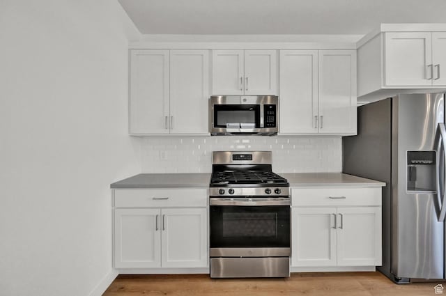 578 S 1080 W, American Fork, UT 84003 - kitchen with white cabinets, light wood-type flooring, decorative backsplash, and stainless steel appliances
