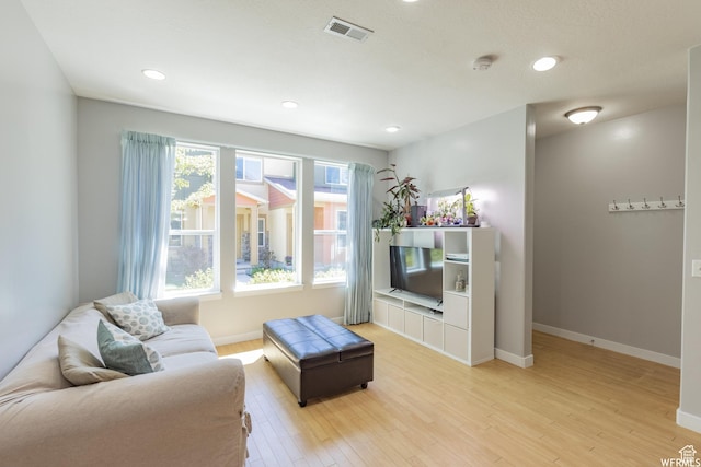 living area with light wood finished floors, baseboards, visible vents, and recessed lighting
