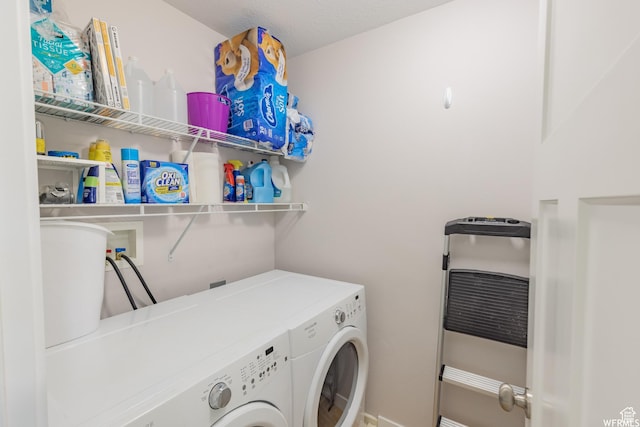laundry area featuring laundry area, washing machine and dryer, and heating unit