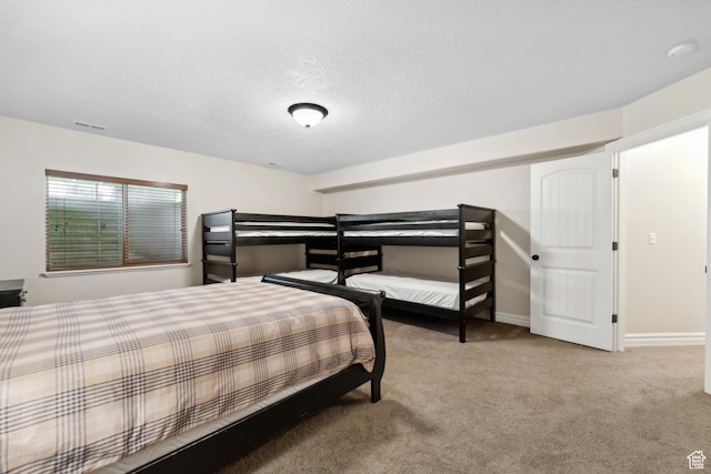 carpeted bedroom featuring visible vents, baseboards, and a textured ceiling