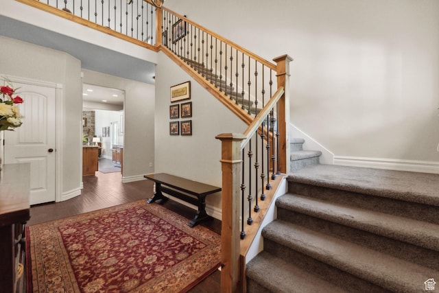 stairway featuring recessed lighting, baseboards, and wood finished floors